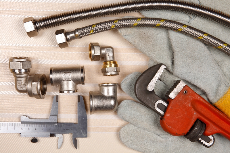 Plumber working on pipes in a Merton home