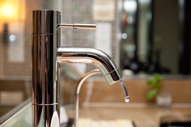 Leaking tap being repaired in Merton